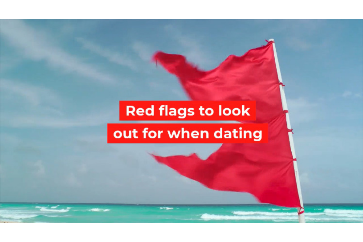 red flag blowing in the wind on the beach