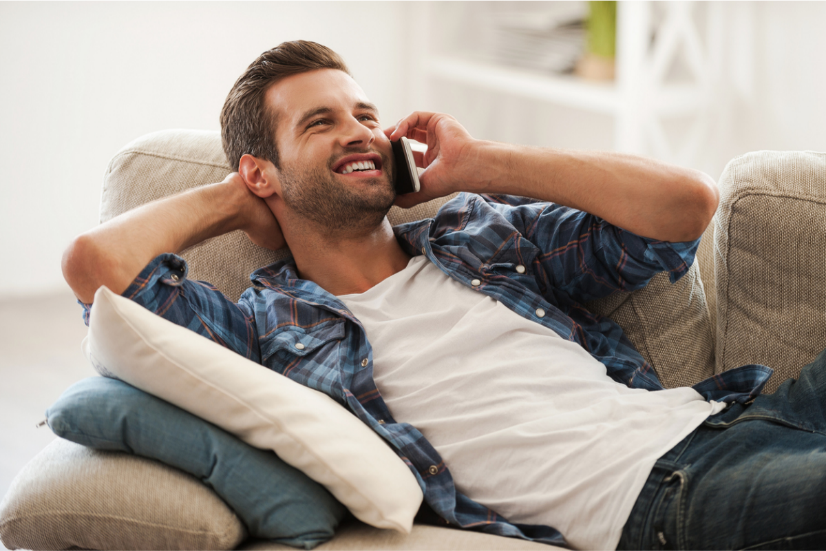 man on a sofa chatting on the phone