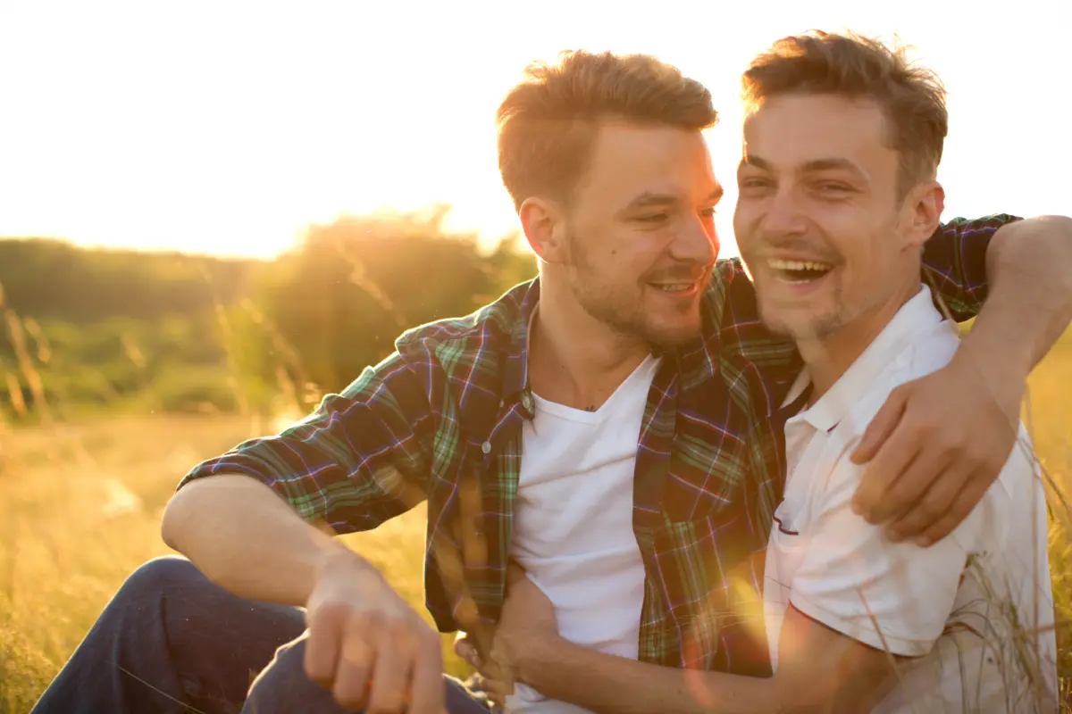 Hot gay men hugging in a field